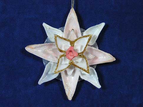 Pink and white seashell flower ornament with gold trim and glitter.