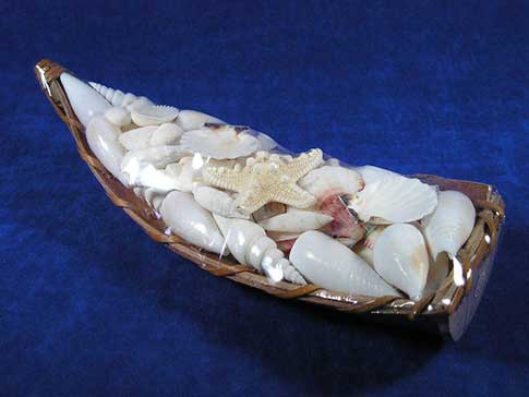 Seashells in rustic boat used as wedding decor then turned into home decor.